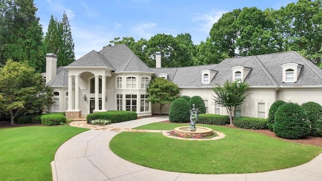 french country home featuring a front lawn