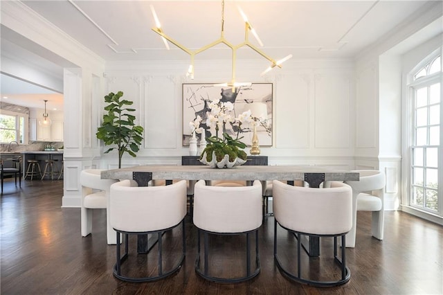 dining space featuring ornamental molding, dark hardwood / wood-style flooring, and ornate columns