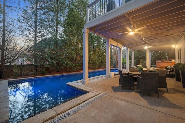 pool at dusk featuring a hot tub, a patio, and ceiling fan