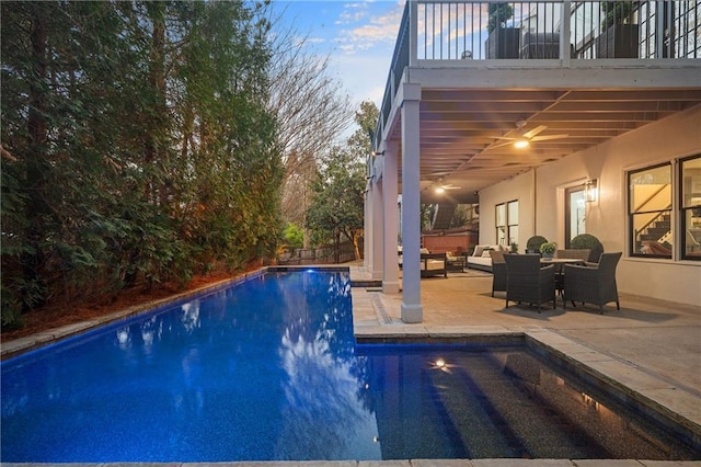 pool at dusk featuring an outdoor hangout area and a patio area