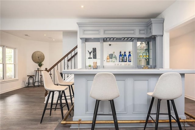 bar with dark hardwood / wood-style floors and gray cabinetry