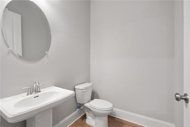 bathroom featuring toilet, hardwood / wood-style floors, and sink