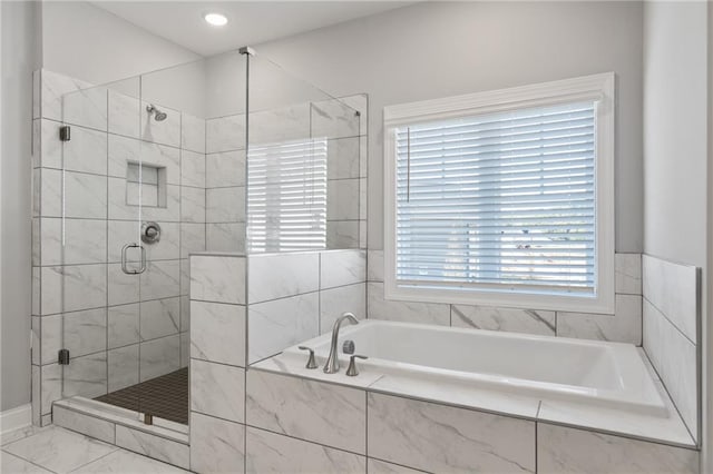 bathroom featuring independent shower and bath and a wealth of natural light