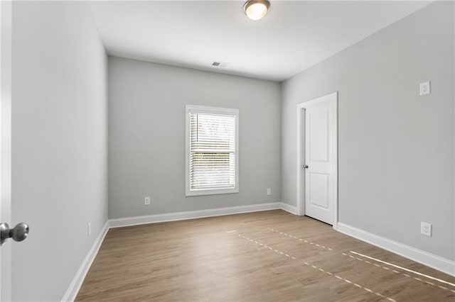 unfurnished room with hardwood / wood-style flooring