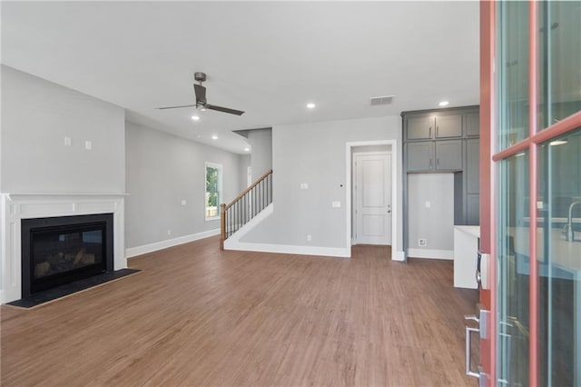 unfurnished living room with light hardwood / wood-style floors and ceiling fan