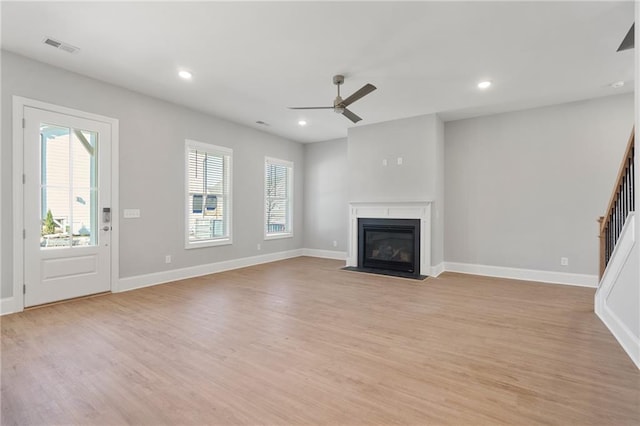 unfurnished living room featuring a wealth of natural light, light hardwood / wood-style flooring, and ceiling fan