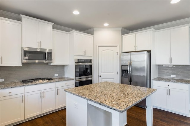 kitchen featuring dark wood-style floors, stainless steel appliances, a kitchen island, and white cabinetry