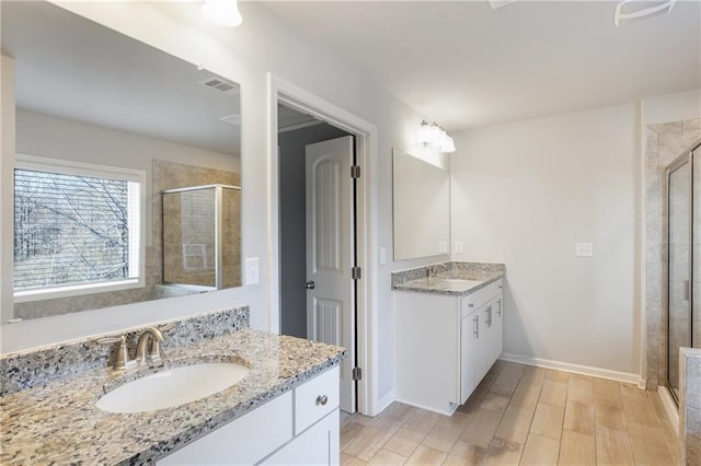 bathroom with a sink, visible vents, and a shower stall