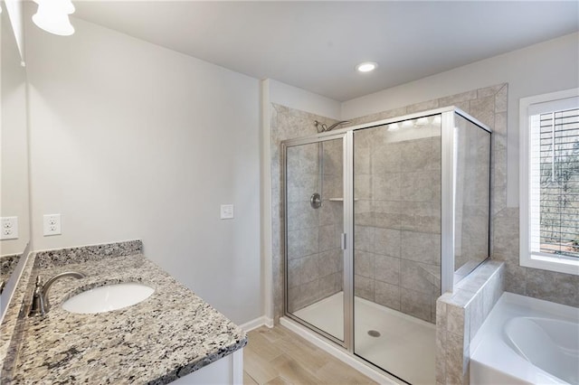 full bathroom featuring a garden tub, a shower stall, wood finished floors, and vanity