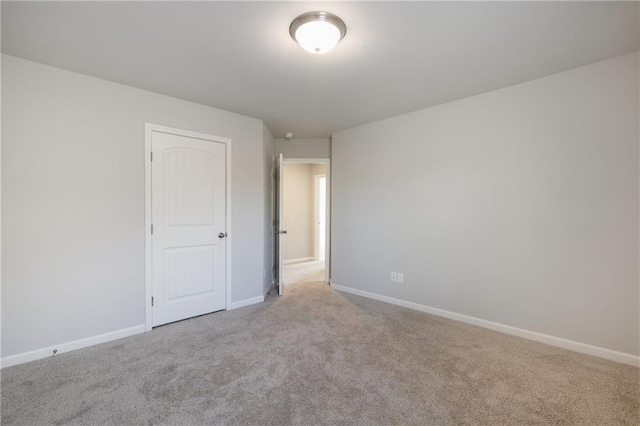 carpeted empty room with baseboards