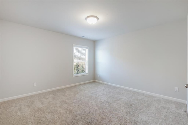 spare room with carpet floors, visible vents, and baseboards