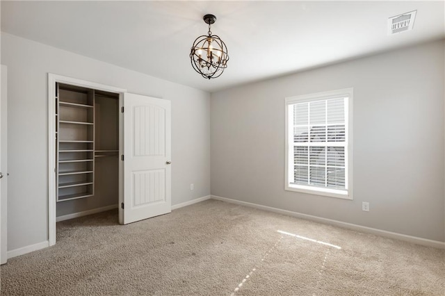 unfurnished bedroom with carpet floors, baseboards, visible vents, and a chandelier