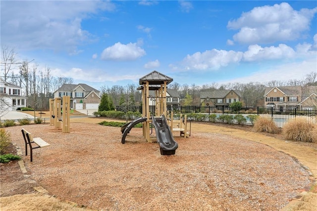 community play area with a residential view and fence