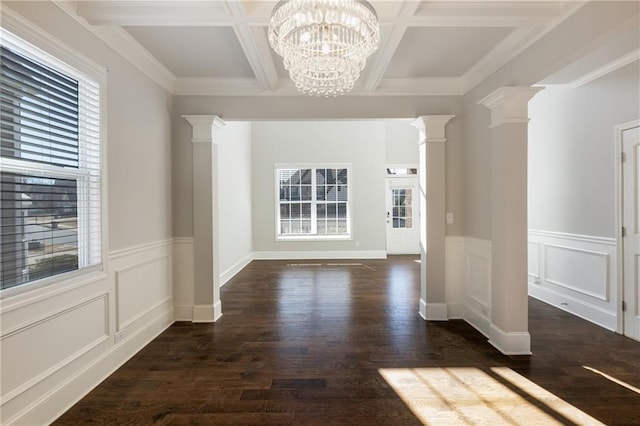 unfurnished dining area featuring coffered ceiling, wood finished floors, beam ceiling, decorative columns, and an inviting chandelier