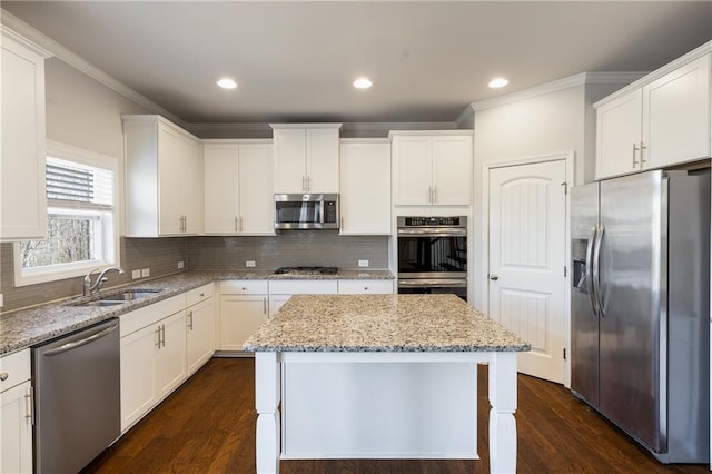 kitchen with white cabinetry, appliances with stainless steel finishes, backsplash, and a sink