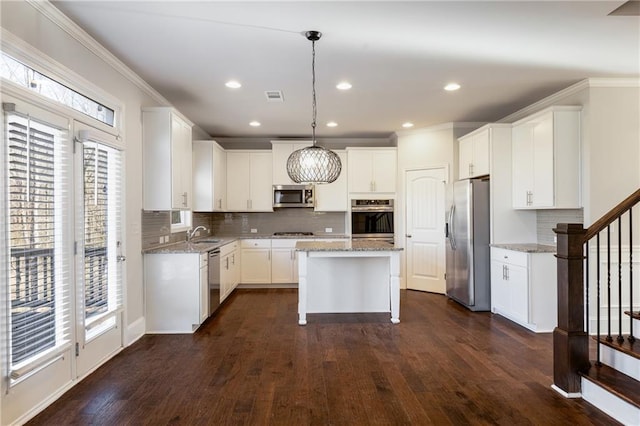 kitchen with stainless steel appliances, a wealth of natural light, visible vents, and light stone countertops