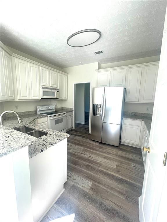 203 Sea Marsh Ct, Fayetteville, GA 30215 - kitchen with white appliances, a sink, light stone counters, dark wood finished floors, and a textured ceiling