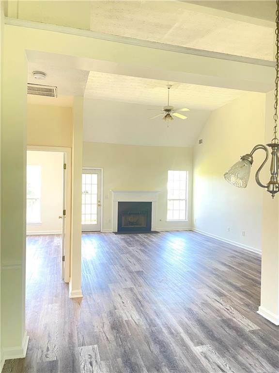 203 Sea Marsh Ct, Fayetteville, GA 30215 - unfurnished living room with healthy amount of natural light, ceiling fan, lofted ceiling, baseboards, and wood finished floors