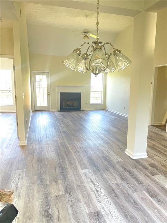 203 Sea Marsh Ct, Fayetteville, GA 30215 - unfurnished living room featuring baseboards, a fireplace, a chandelier, wood finished floors, and high vaulted ceiling