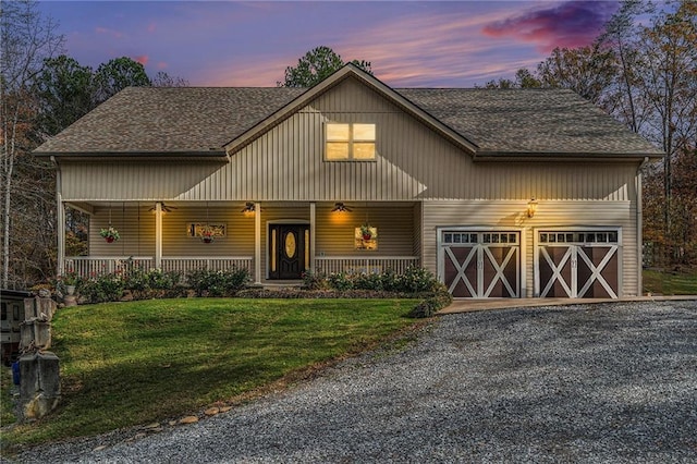 view of front of home featuring a yard, a porch, and a garage