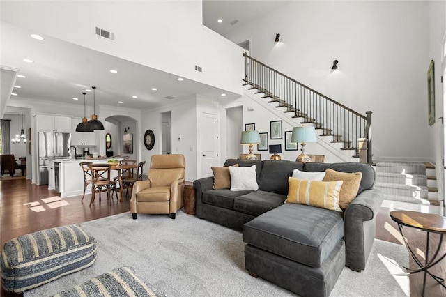 635 Opera Ln, Alpharetta, GA 30009 - living room with arched walkways, a high ceiling, recessed lighting, stairway, and dark wood finished floors