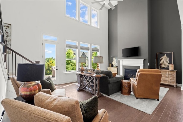 635 Opera Ln, Alpharetta, GA 30009 - living room featuring ceiling fan, a high ceiling, a glass covered fireplace, healthy amount of natural light, and wood finished floors