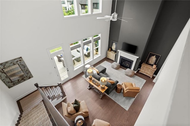635 Opera Ln, Alpharetta, GA 30009 - living area with healthy amount of natural light, a towering ceiling, a glass covered fireplace, ceiling fan, and wood finished floors
