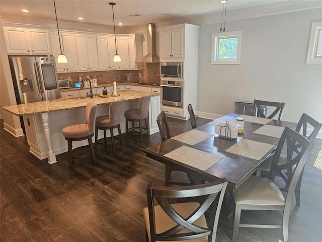 124 Archstone Sq, Mcdonough, GA 30253 - dining space featuring dark wood-style floors, crown molding, recessed lighting, and baseboards