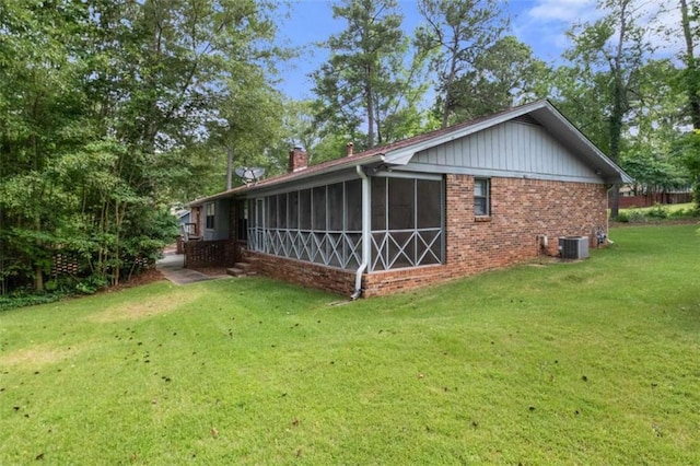 rear view of property featuring a yard and a sunroom