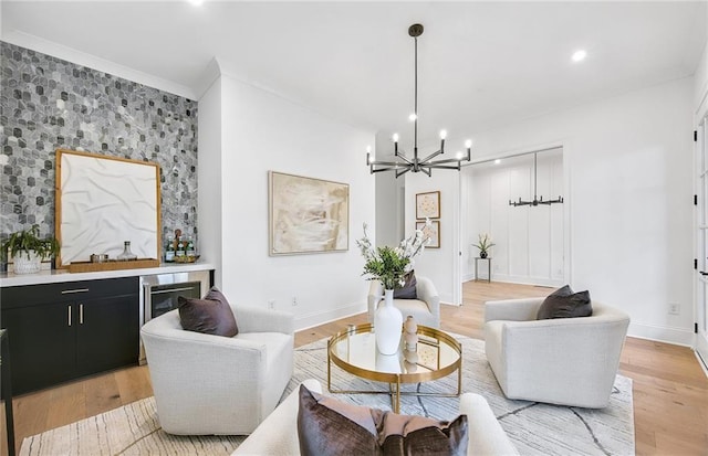 living room with wood-type flooring, a chandelier, and ornamental molding