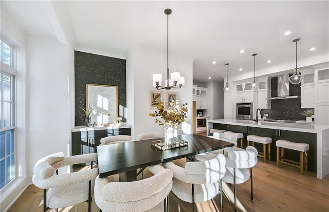 dining space with sink, a chandelier, and hardwood / wood-style floors