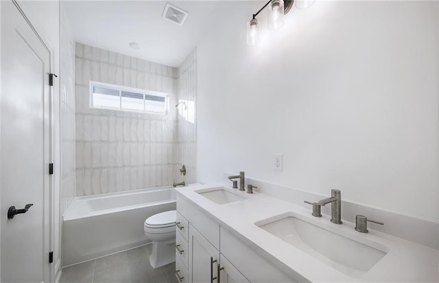 full bathroom with toilet, tiled shower / bath, tile patterned floors, and vanity