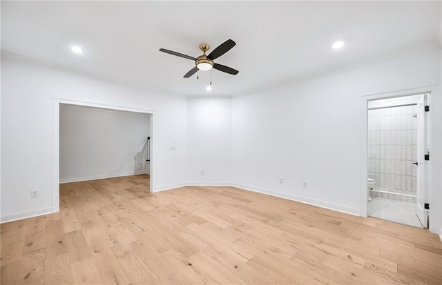 empty room with ceiling fan and light hardwood / wood-style flooring