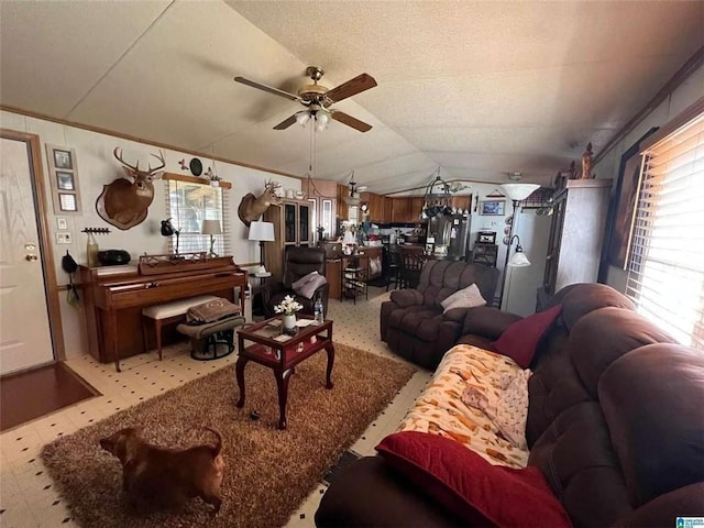 living area featuring a ceiling fan, vaulted ceiling, and tile patterned floors