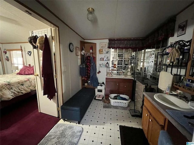 ensuite bathroom with tile patterned floors, a sink, and ornamental molding