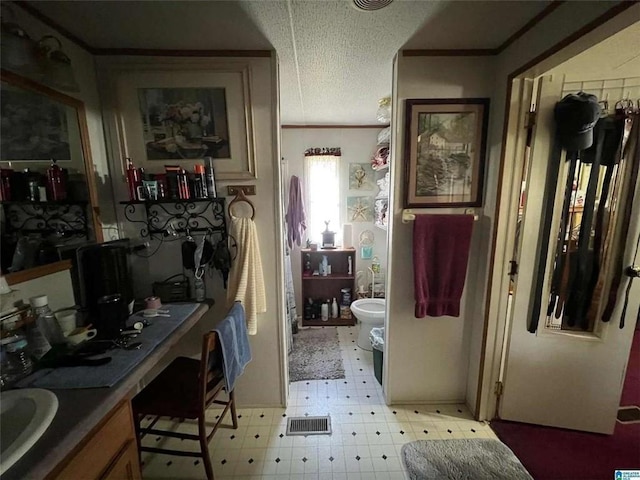 bathroom with tile patterned floors, a bidet, ornamental molding, and a textured ceiling