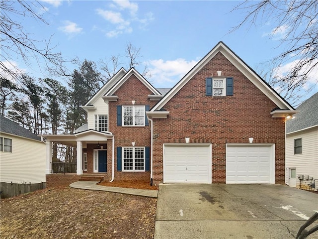 traditional home featuring a garage, brick siding, driveway, and a porch