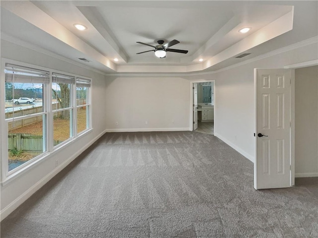 carpeted empty room featuring baseboards, a tray ceiling, ornamental molding, and recessed lighting