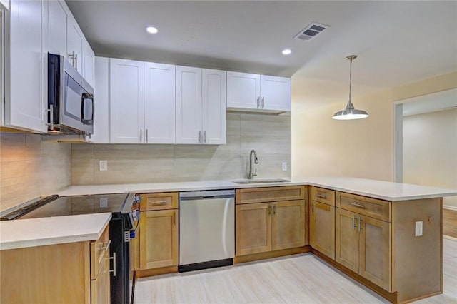kitchen with visible vents, stainless steel appliances, light countertops, and a sink