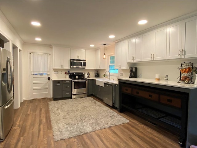 kitchen featuring appliances with stainless steel finishes, white cabinets, dark wood-type flooring, and light countertops