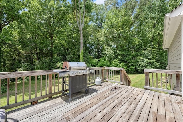 wooden terrace featuring area for grilling and a yard