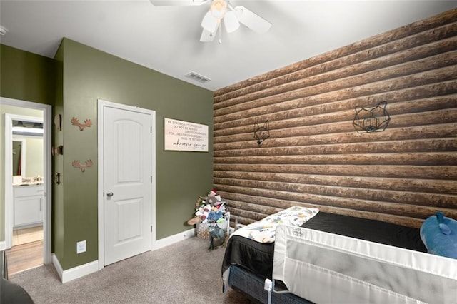 carpeted bedroom with ensuite bath and ceiling fan