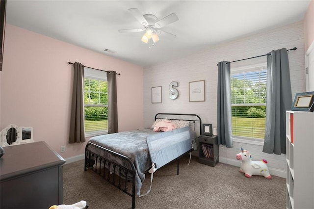 bedroom featuring multiple windows, dark colored carpet, and ceiling fan