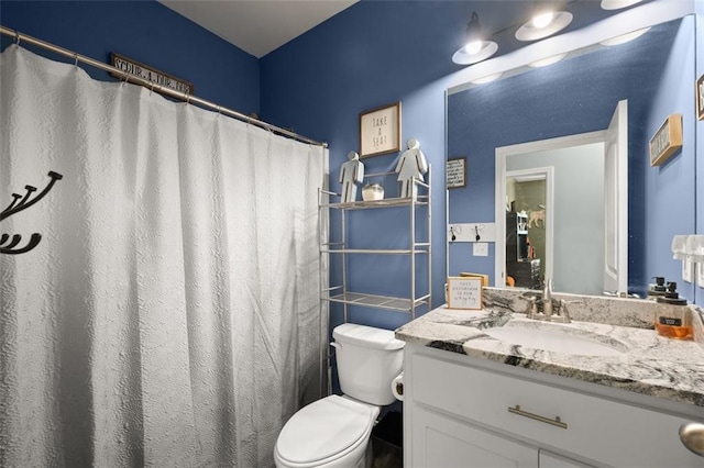 bathroom with vanity, curtained shower, and toilet