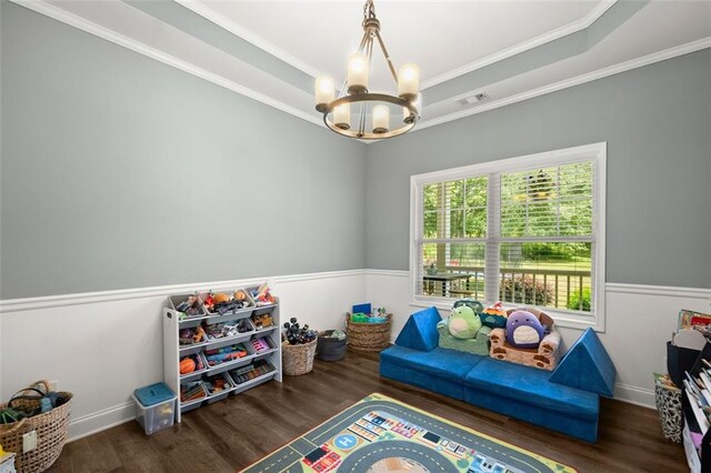 recreation room featuring dark hardwood / wood-style floors, an inviting chandelier, and crown molding