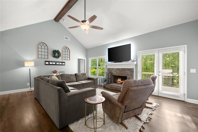 living room featuring ceiling fan, dark hardwood / wood-style flooring, beamed ceiling, and a healthy amount of sunlight