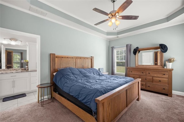 bedroom with ceiling fan, light colored carpet, multiple windows, and a tray ceiling