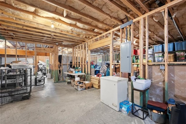 basement featuring refrigerator and electric panel