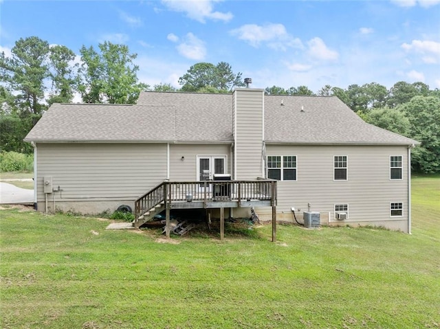 rear view of property featuring central air condition unit, a lawn, and a wooden deck