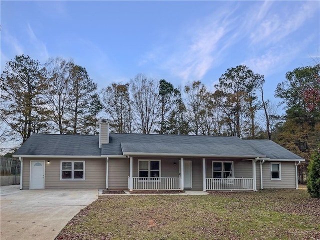 ranch-style home featuring covered porch and a front lawn